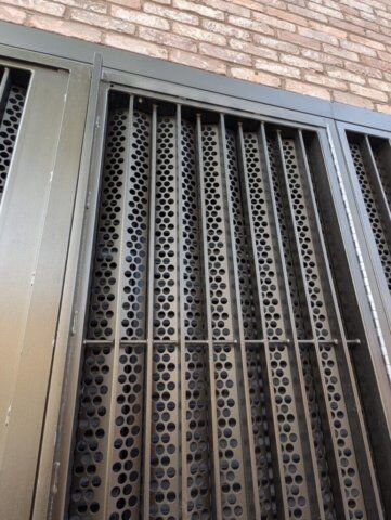 LPS1175 SR2 gates with perforated mesh infill Louvre security door with perforated metal design, showcasing strength and durability, part of Secure by Design accredited installations for enhanced safety in residential and commercial properties.