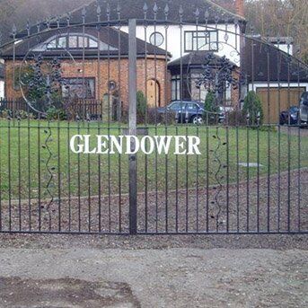 ORNATE STEEL GATES Wrought iron security gate with decorative elements and the name "GLENDOWER," providing an entrance to a residential property, emphasizing security and design in line with Secure by Design principles.