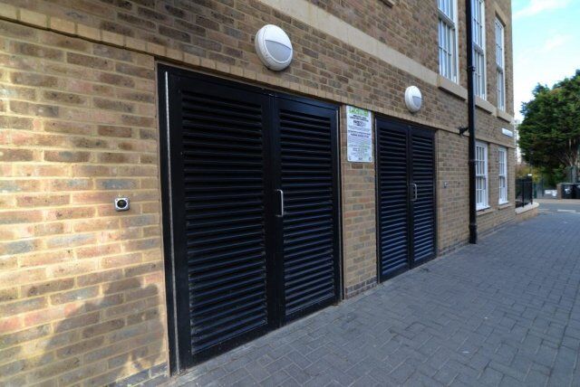 Secure by Design accredited louvre doors in a brick wall, showcasing durability and aesthetic integration for enhanced security in residential and commercial properties.