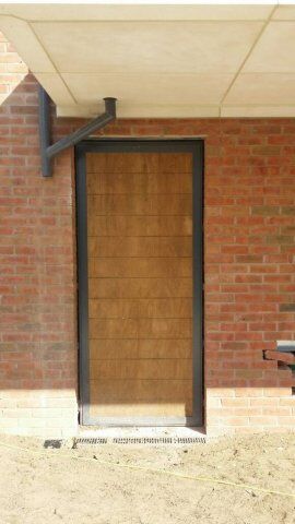 Secure by Design accredited wooden security door installed in a brick wall, showcasing durability and strength for enhanced safety in residential or commercial properties.