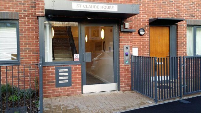 Entrance of St Claude House featuring secure access control system, modern design, and adjacent mailboxes, emphasizing safety and accessibility for residents.