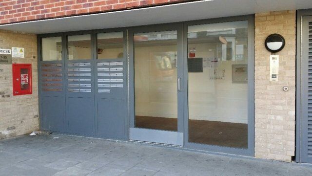 Secure by Design accredited gray entrance doors with horizontal slats, enhancing security and aesthetics for commercial properties.
