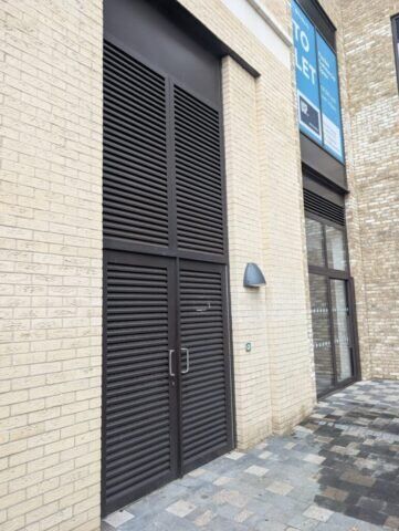 Secure by Design accredited louvre security door in a brick building, showcasing durability and modern aesthetics for enhanced safety.