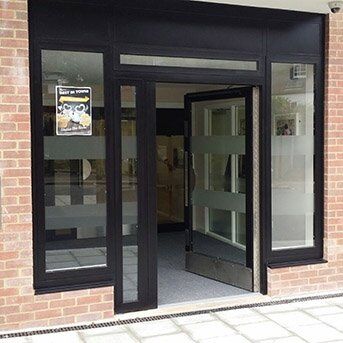 Secure by Design accredited communal doors with glass panels and black frames, showcasing modern design and durability for enhanced security installations.