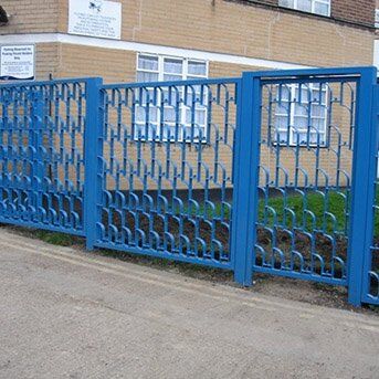 Blue security gate with decorative pattern, installed in a residential area, showcasing durability and design in line with Secure by Design standards.