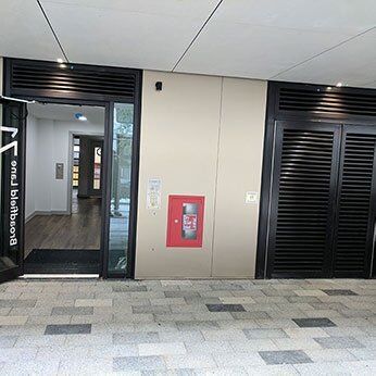 Entrance featuring Secure by Design accredited doors, fire extinguisher, and louvre panels, enhancing safety and accessibility for residential and commercial properties.