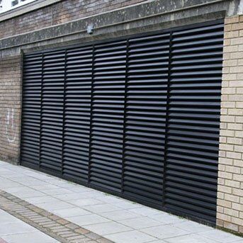 Louvre security door installation featuring horizontal slats, enhancing safety and aesthetics for building access points, aligned with Secure by Design standards.